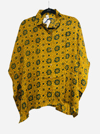Yellow and green patterned shirt on a hanger against a white background