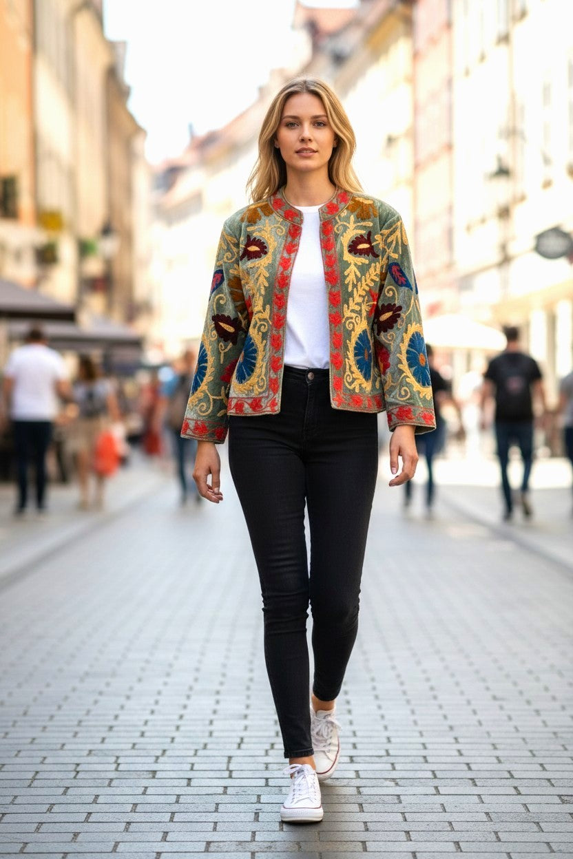 Model wearing a Les Sûtras Velvet Suzani - Embroidered Jacket - Green walking on a city street.