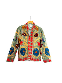 Les Sûtras colourful Velvet Suzani - Embroidered Green Jacket on a hanger against a white background