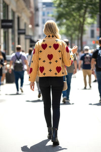 Model wearing Les Sûtras Velvet Suzani Embroidered Jacket - Ivory with Pink Hearts.